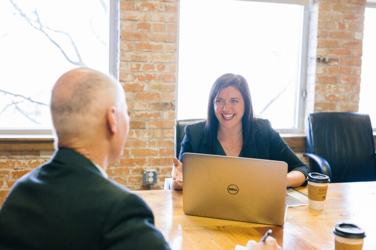 financial advisor smiling at a client from behind a computer